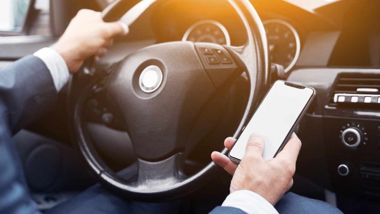 Conductor consultando una app de puntos de recarga en el móvil