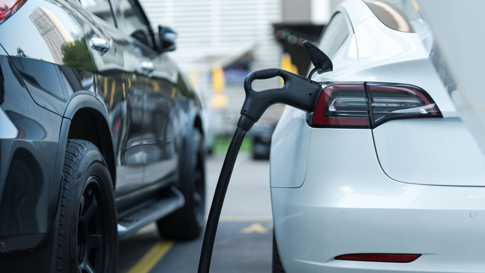 Coche eléctrico enchufado a un cargador mostrando el nivel de carga de la batería