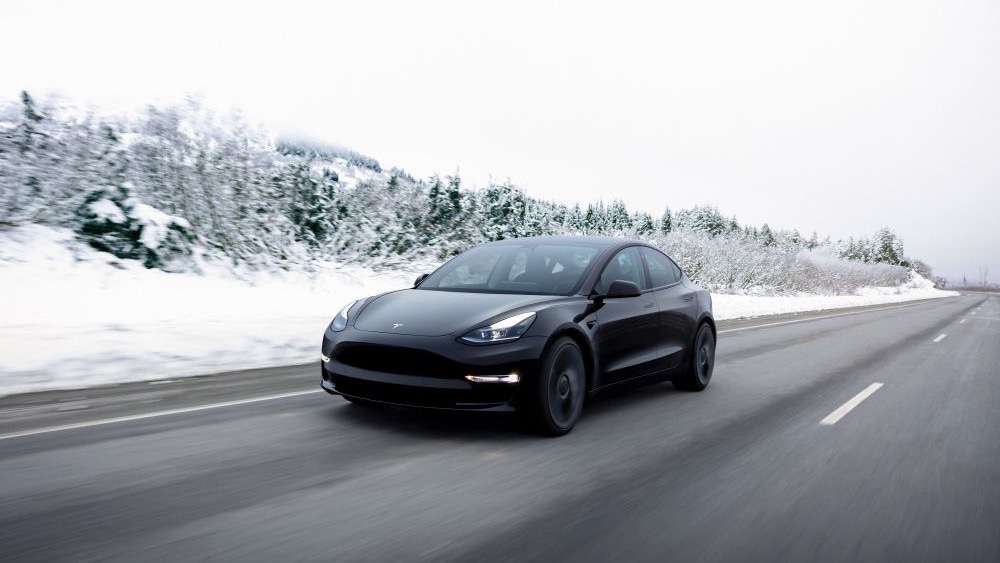 Coche eléctrico circulando por una carretera nevada