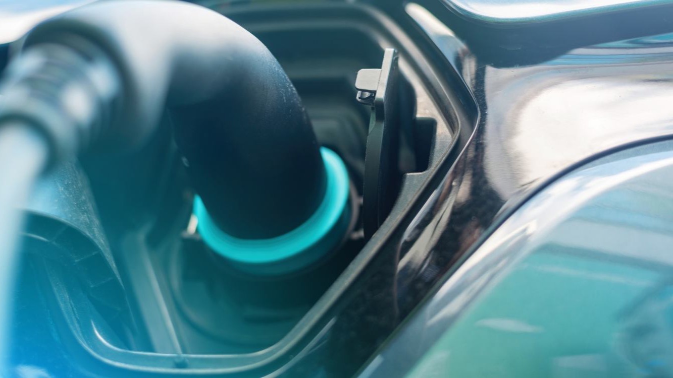 Coche eléctrico cargando con el coste de la recarga en pantalla