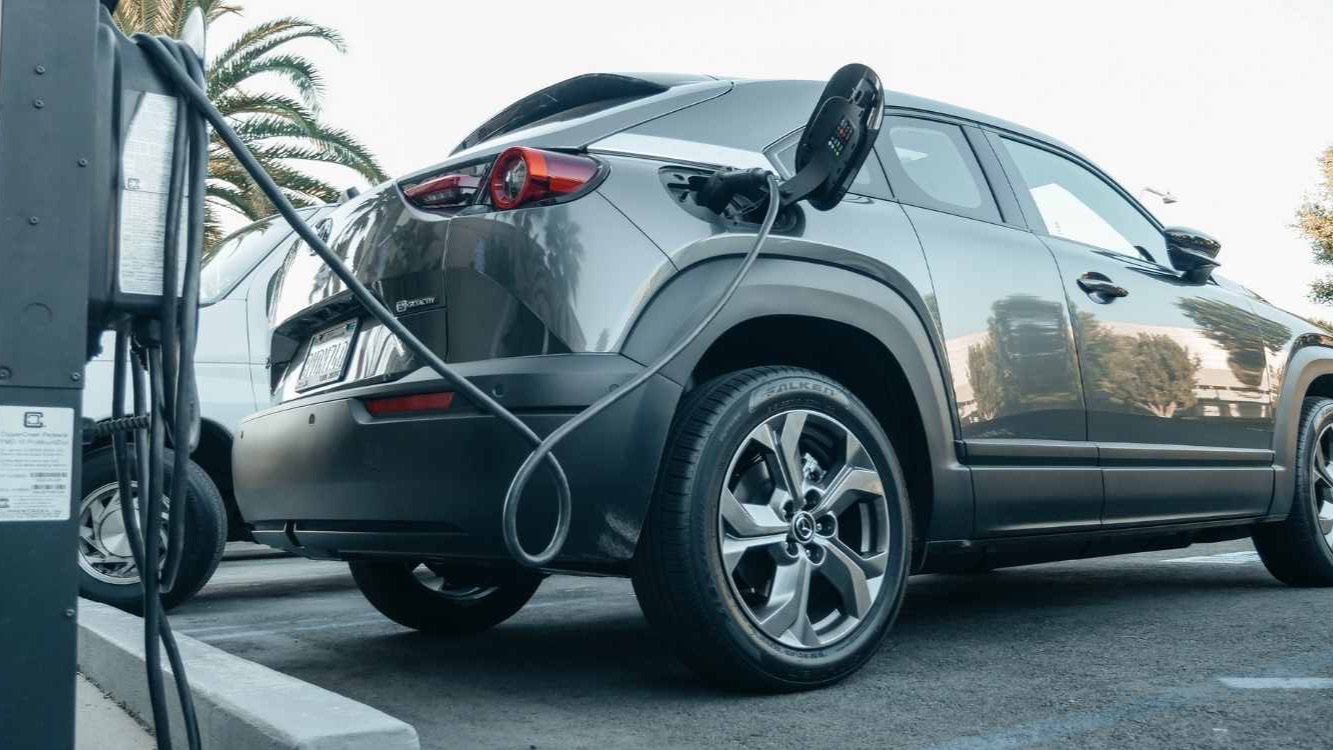 Conductor valorando las ventajas y desventajas de un coche eléctrico